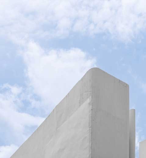 Building-White-Concrete-Wall-with-Geometric-Triangle-View-Against-Blue-SkyCloud-Background.jpg